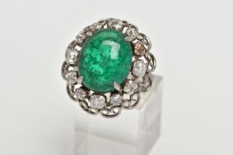 AN EMERALD AND DIAMOND WHITE METAL CLUSTER RING, the principal oval cabochon emerald, measuring