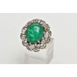 AN EMERALD AND DIAMOND WHITE METAL CLUSTER RING, the principal oval cabochon emerald, measuring