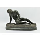 A 19TH CENTURY CARVED SERPENTINE FIGURE OF THE DYING GAUL, AFTER THE ANTIQUE, on an integral oval