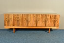 GORDON RUSSELL (BRITISH 1892-1980) A 1960'S ROSEWOOD AND TEAK 7FT SIDEBOARD, the six doors with book