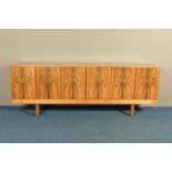 GORDON RUSSELL (BRITISH 1892-1980) A 1960'S ROSEWOOD AND TEAK 7FT SIDEBOARD, the six doors with book