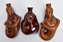 TWO VICTORIAN TREACLE GLAZED FLASKS IN THE FORM OF MERMAIDS, heights 20cm and 18cm and another
