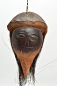 A 19TH/ EARLY 20TH CENTURY CARVED COCONUT, the outer shell and husk forming hat and hair, the
