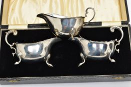 A CASED PAIR OF GEORGE VI SILVER SAUCEBOATS, of oval form, S scroll handles, wavy rims, three