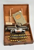 AN EARLY 20TH CENTURY BLICK ALUMINIUM FEATHERWEIGHT TYPEWRITER FITTED IN THE ORIGINAL OAK STORAGE