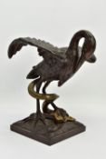 A 19TH CENTURY BRONZE FIGURE OF A STORK STANDING WITH OUTSTRETCHED WINGS, clutching an eel to the