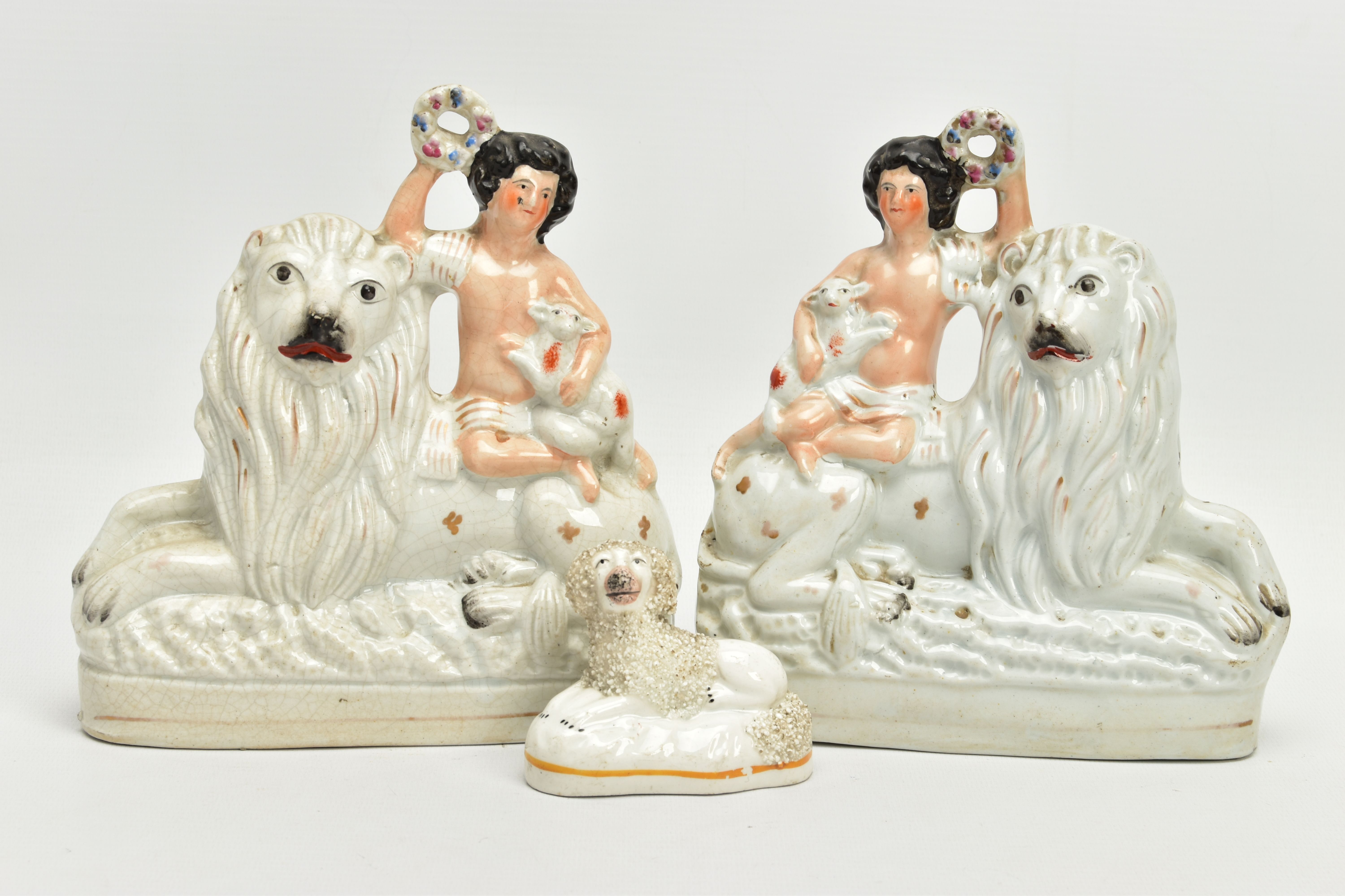 A PAIR OF VICTORIAN STAFFORDSHIRE POTTERY FIGURE GROUPS, modelled as a naked boy holding a garland a