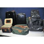 A COLLECTION OF LUGGAGE to include two hard gloss black hard shell suitcases, two Antler holdalls,