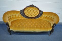 A LATE VICTORIAN WALNUT SOFA, the oval centre surrounded by open foliate decoration, buttoned gold