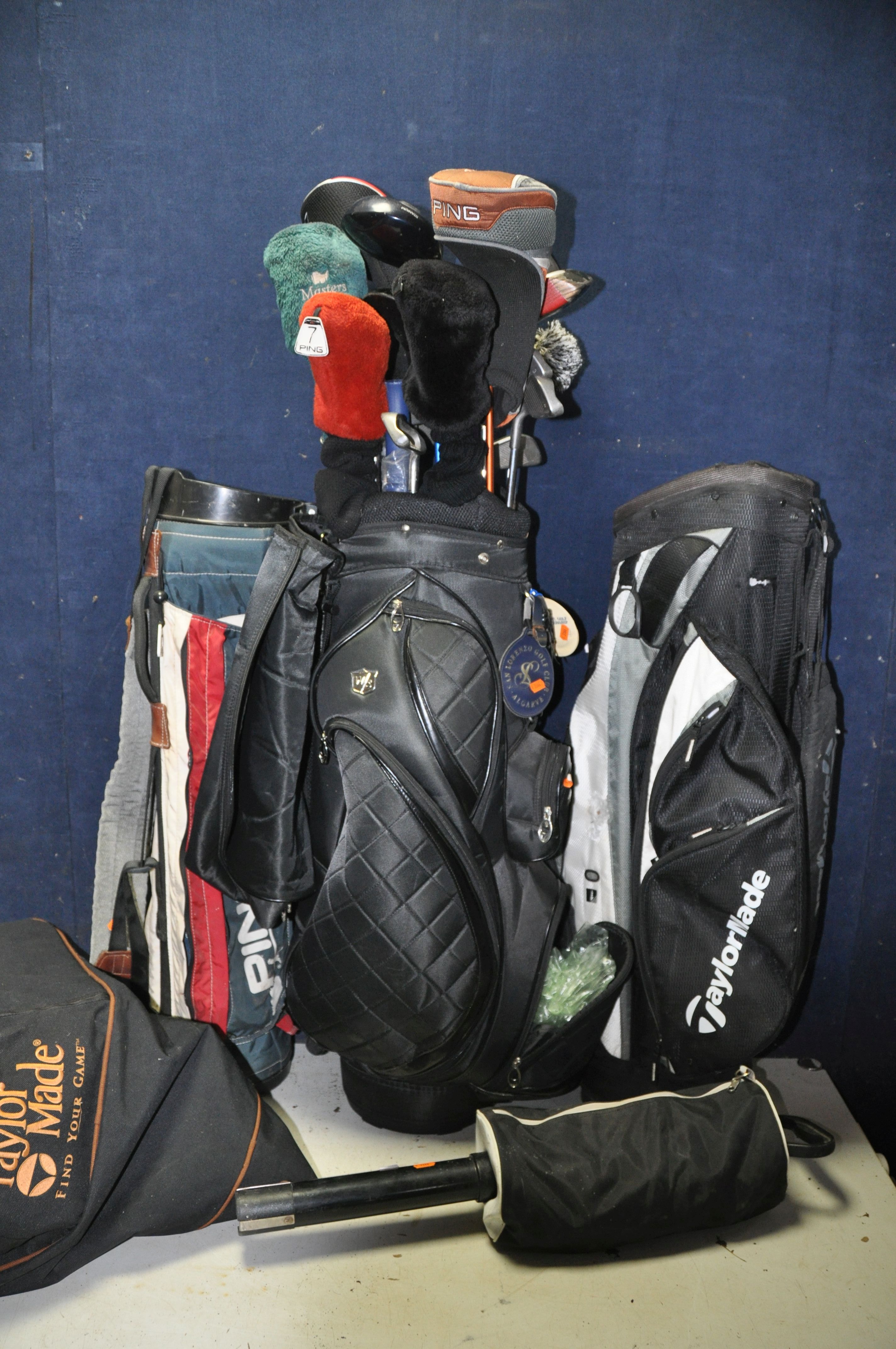 GOLFING EQUIPMENT to include three empty golf bags, a Ping, two Taylor made and a Wilson Staff