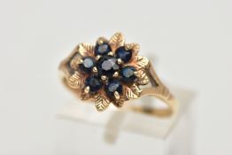 A 9CT GOLD SAPPHIRE CLUSTER RING, designed as a floral cluster set with seven circular cut