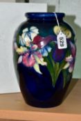 A WALTER MOORCROFT BALUSTER VASE DECORATED WITH AN ORCHID DESIGN ON A BLUE / GREEN GROUND, impressed