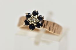 A 1970S 9CT GOLD SAPPHIRE AND DIAMOND CLUSTER RING, AF, the single cut diamond, within a surround of