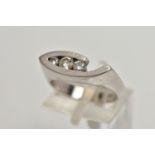 A WHITE METAL DIAMOND RING, the ring head of an abstract lozenge shape, set with three graduated