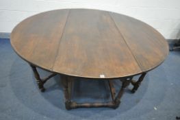 A LARGE REPRODUCTION GEORGIAN STYLE OAK GATE LEG TABLE, the drop leaves each with double legs,