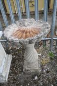 A COMPOSITE SHELL SHAPED BIRD BATH, on a separate spiralling base, diameter 52cm x height 80cm (