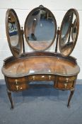 A QUEEN ANNE STYLE WALNUT KIDNEY DRESSING TABLE, with triple mirror, glass top, an assortment of