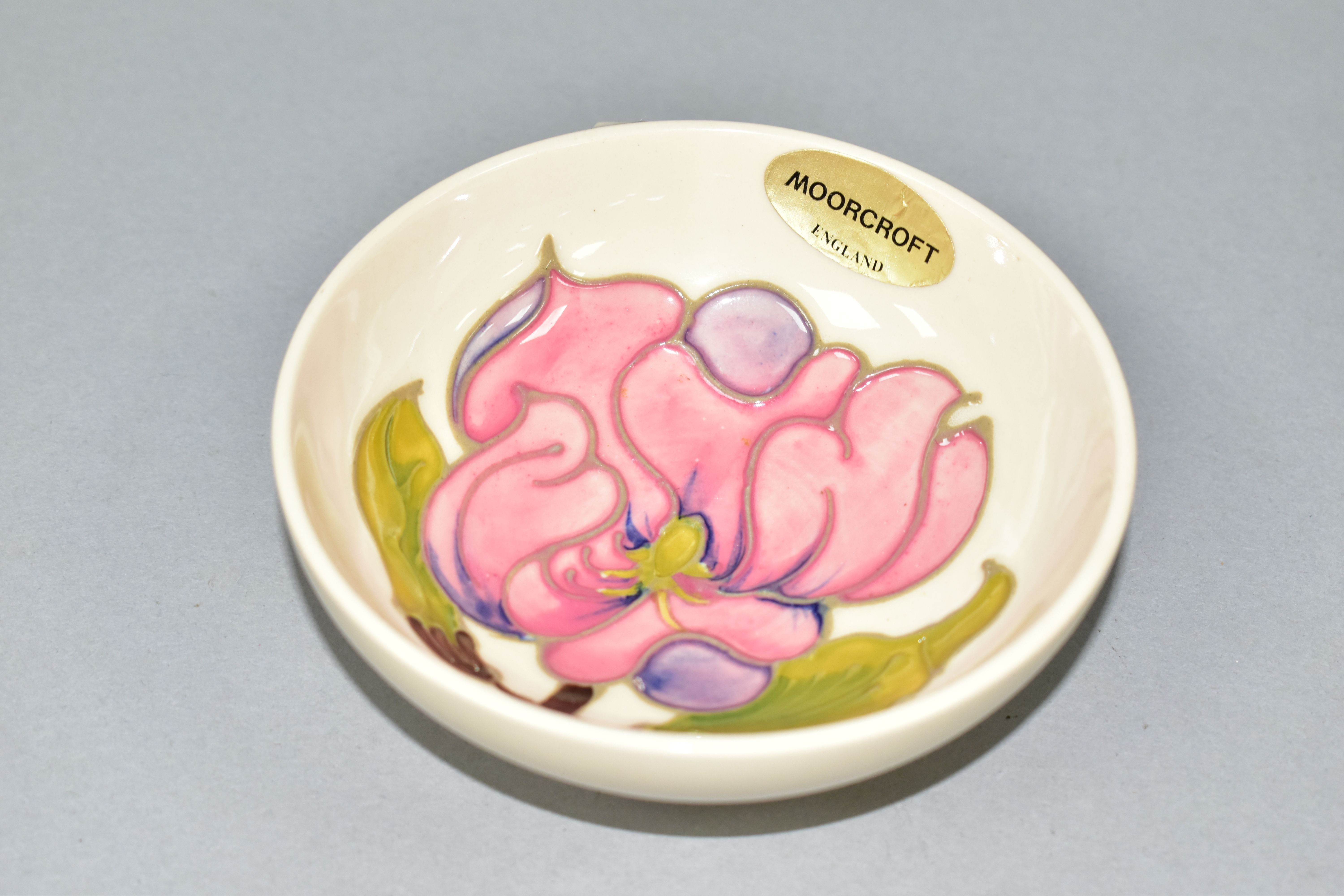 A SMALL MOORCROFT POTTERY MAGNOLIA FOOTED BOWL, with pink magnolia blooms on a cream ground,