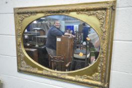 A MID TO LATE 20TH CENTURY FRENCH GILT FRAMED WALL MIRROR, with an oval plate 91cm x 66cm