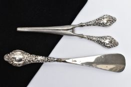 A SILVER HANDLED SHOEHORN AND GLOVE STRETCHERS, a matching set detailing a scrolling foliage design,