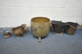 A BRASS LOG BUCKET, with twin lion handles, and three claw feet, a copper log bucket, with two
