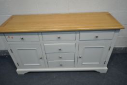 A WHITE PAINTED SIDEBOARD, with light oak top, six various drawers and two cupboard doors, length