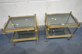 A PAIR OF MID CENTURY SMALL BRASS TROLLEYS, two trays with smoked glass inserts, length 50cm x depth