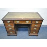 AN EARLY 20TH CENTURY MAHOGANY KNEE HOLE DESK, with green tooled leather inlay, nine assorted