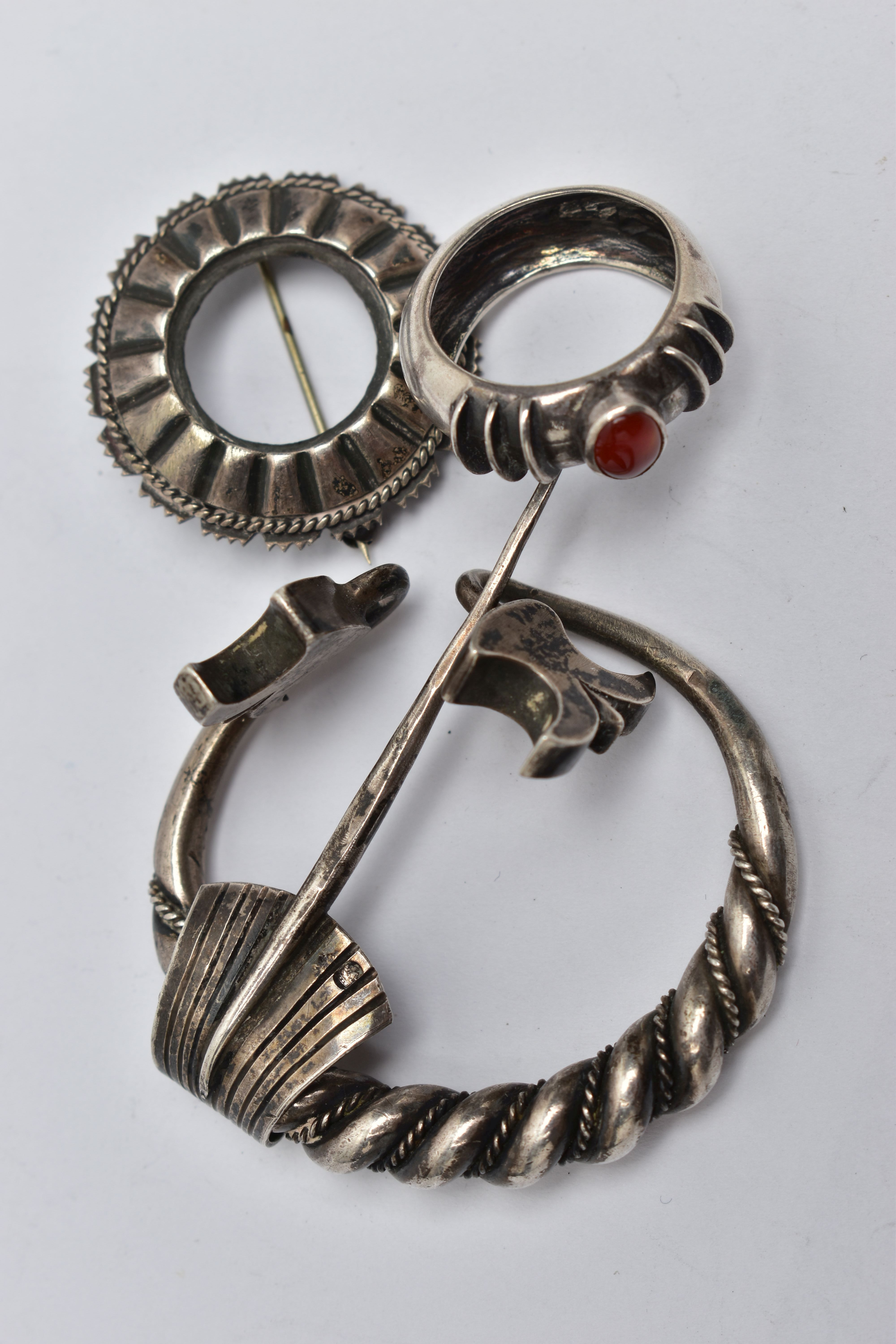 A CLOAK CLIP, BROOCH AND A RING, the white metal cloak clip of a circular form, featuring rope twist