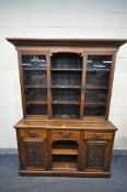 A LATE 19TH CENTURY OAK DRESSER, the top with overhanging cornice, two glazed doors, flanking