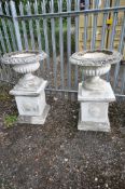 A PAIR OF COMPOSITE CAMPAGNA GARDEN URNS, of a shallow form, on a separate plinth, diameter 72cm x
