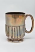 A SILVER MUG, stop reeded pattern, raised on a round base, fitted with a curved handle, worn gilt,