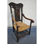A 19TH CENTURY OAK OPEN ARMCHAIR, with a foliate carved back and male mask, rush seat, turned