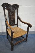 A 19TH CENTURY OAK OPEN ARMCHAIR, with a foliate carved back and male mask, rush seat, turned