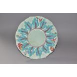 A CLARICE CLIFF 'LEAVES AND BERRIES' PATTERN PLATE, with a painted, relief moulded, wide border of