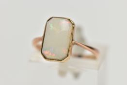A YELLOW METAL OPAL RING, rectangular cut opal cabochon with cut off corners, milgrain collet mount,