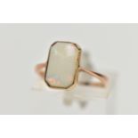 A YELLOW METAL OPAL RING, rectangular cut opal cabochon with cut off corners, milgrain collet mount,