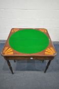 AN EARLY 20TH CENTURY WALNUT FOLD OVER GAMES TABLE, with circular green baize, on tuned legs. 86cm