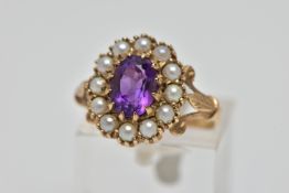 A 9CT GOLD AMETHYST AND SEED PEARL CLUSTER RING, the oval cut amethyst within claw setting to the