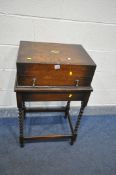 AN OAK CUTLERY CABINET with brass campaign handles, with a single drawer, on a later barley twist