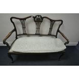 AN EDWARDIAN MAHOGANY SOFA, with a carved cresting, triple pierced splat back, open armrests, on