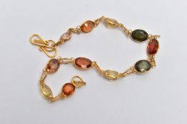 A YELLOW METAL GARNET AND ZIRCON SPECTACLE SET BRACELET, comprised of eleven mixed cut garnets and