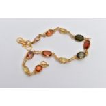 A YELLOW METAL GARNET AND ZIRCON SPECTACLE SET BRACELET, comprised of eleven mixed cut garnets and