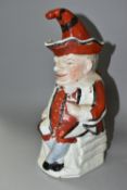 A STAFFORDSHIRE TOBY JUG IN THE FORM OF MR PUNCH, with red, black and white striped outfit, the