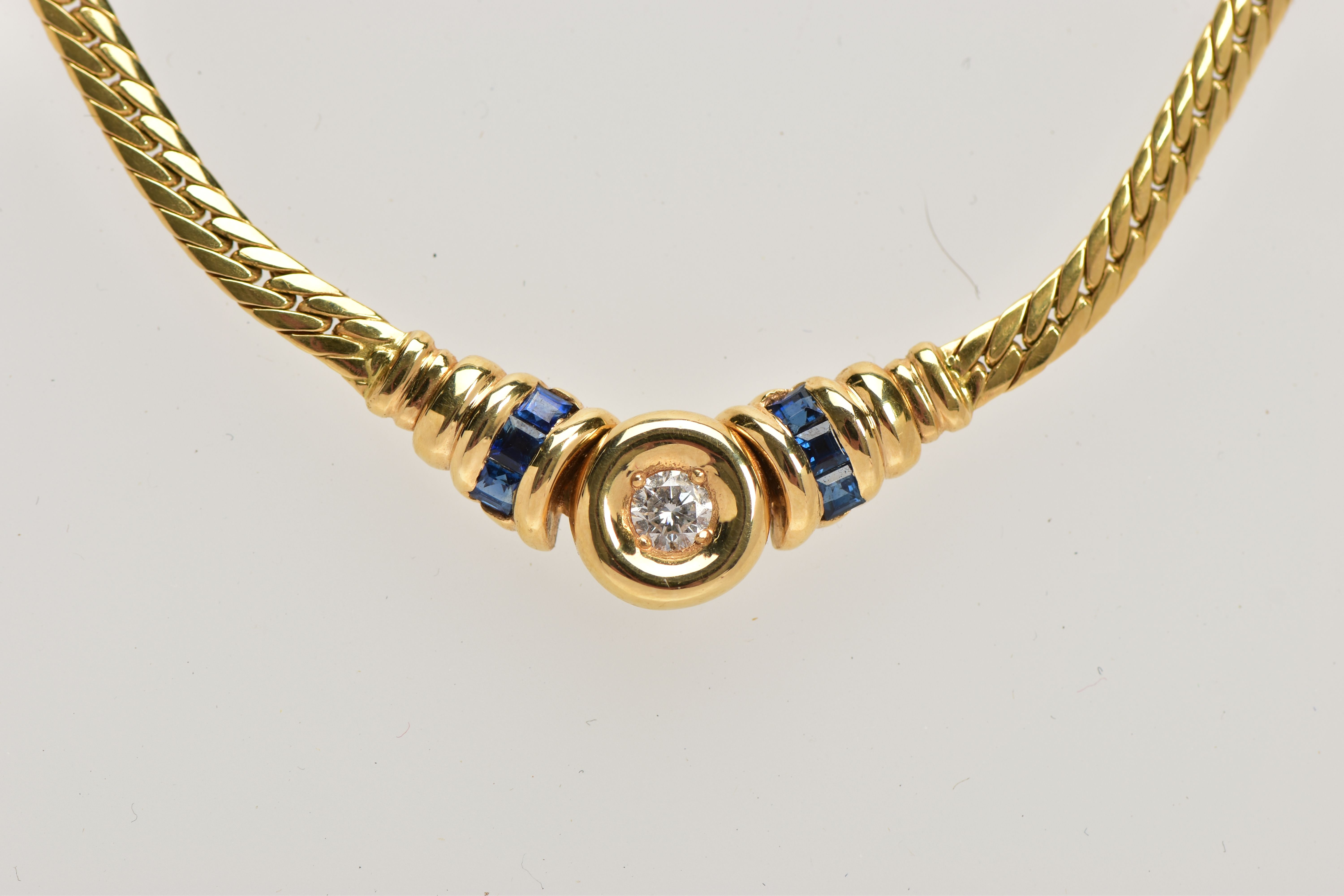A YELLOW METAL DIAMOND AND SAPPHIRE NECKLACE, an articulated flat link chain fitted with a claw