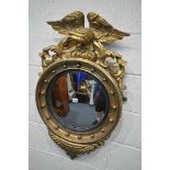 A REGENCY STYLE GILTWOOD CIRCULAR CONVEX WALL MIRROR, with a large bird surmount surrounded by