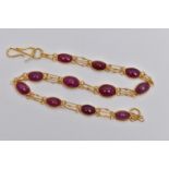 A YELLOW METAL AND RUBY SPECTACLE SET BRACELET, comprised of eleven slightly graduated oval cabochon