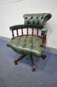 A MAHOGANY FRAMED BUTTONED GREEN LEATHER SWIVEL OFFICE CHAIR, with a scrolled back, on casters (