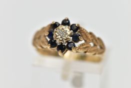 A 9CT GOLD DIAMOND AND SAPPHIRE CLUSTER RING, the illusion set single cut diamond, within a circular