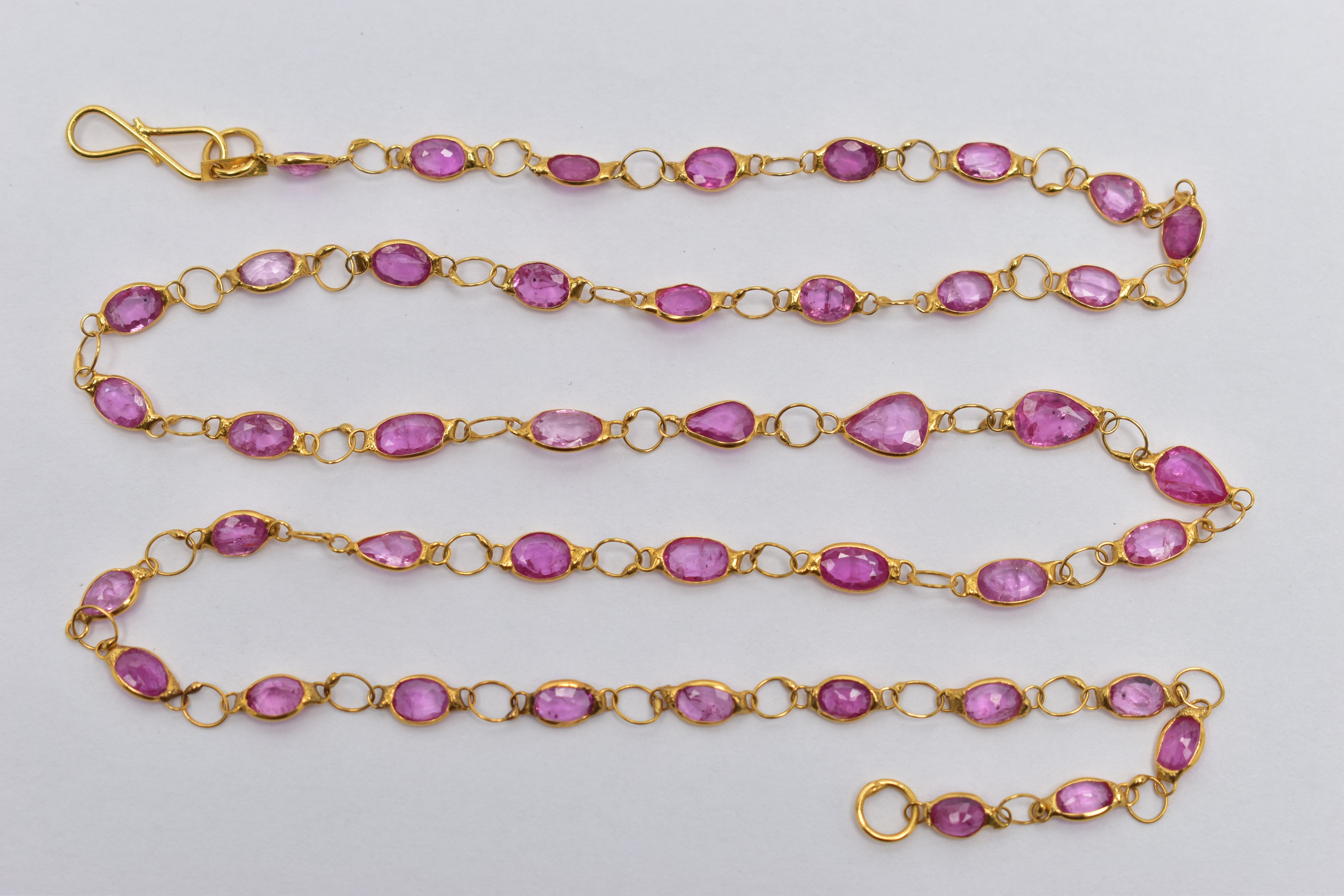 A YELLOW METAL, SAPPHIRE SPECTACLE SET NECKLACE, comprised of forty three mixed cut pink
